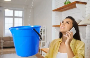 Woman Catching Water From Ceiling In a Bucket