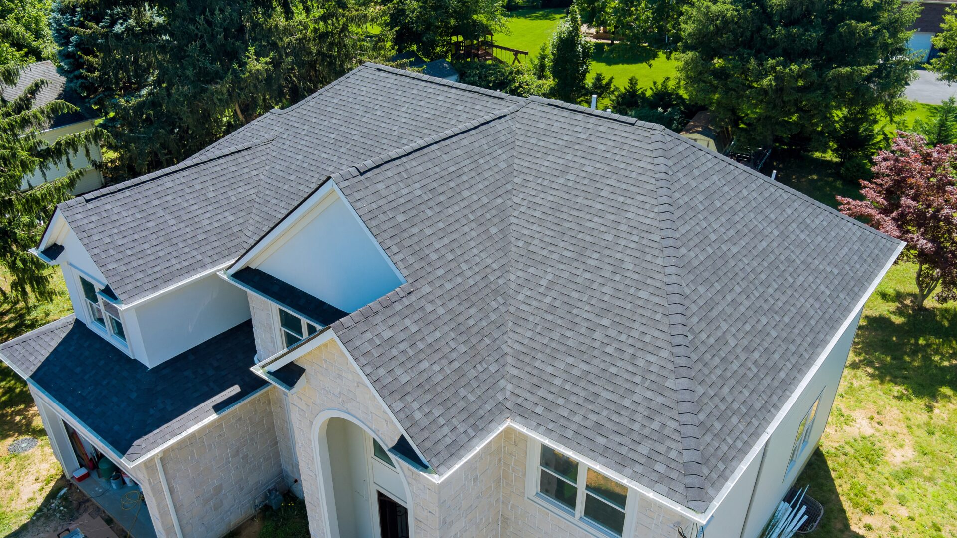 A beautiful new asphalt shingle roof installed on a large home