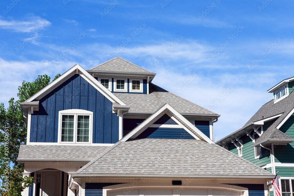 A blue home with a gray composite roof