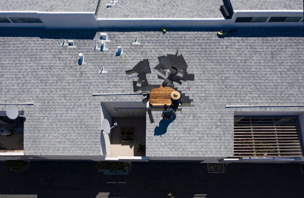 Aerial view of a damaged asphalt roof of a commercial building
